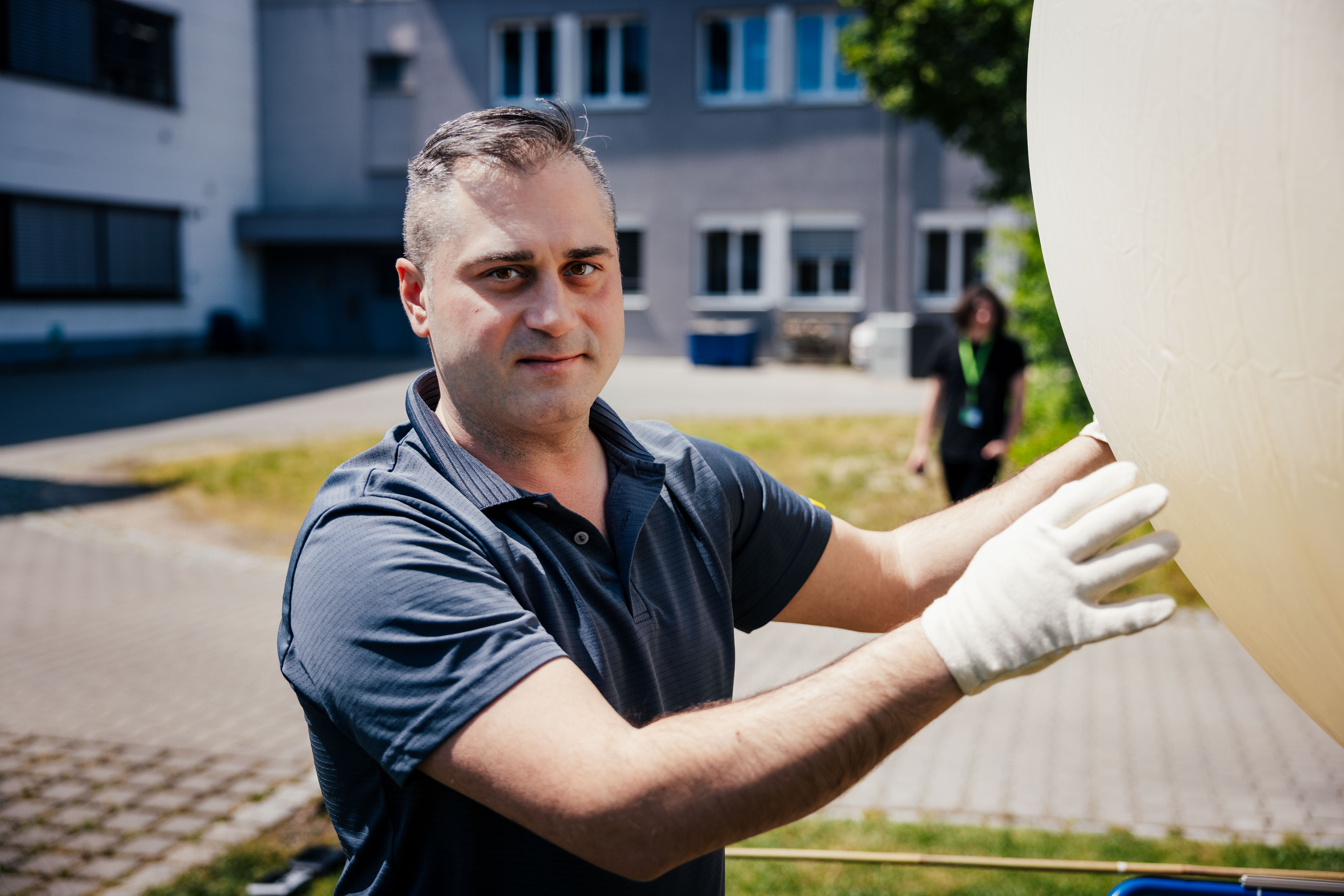 The image shows an employee of Graw Radiosondes filling a balloon