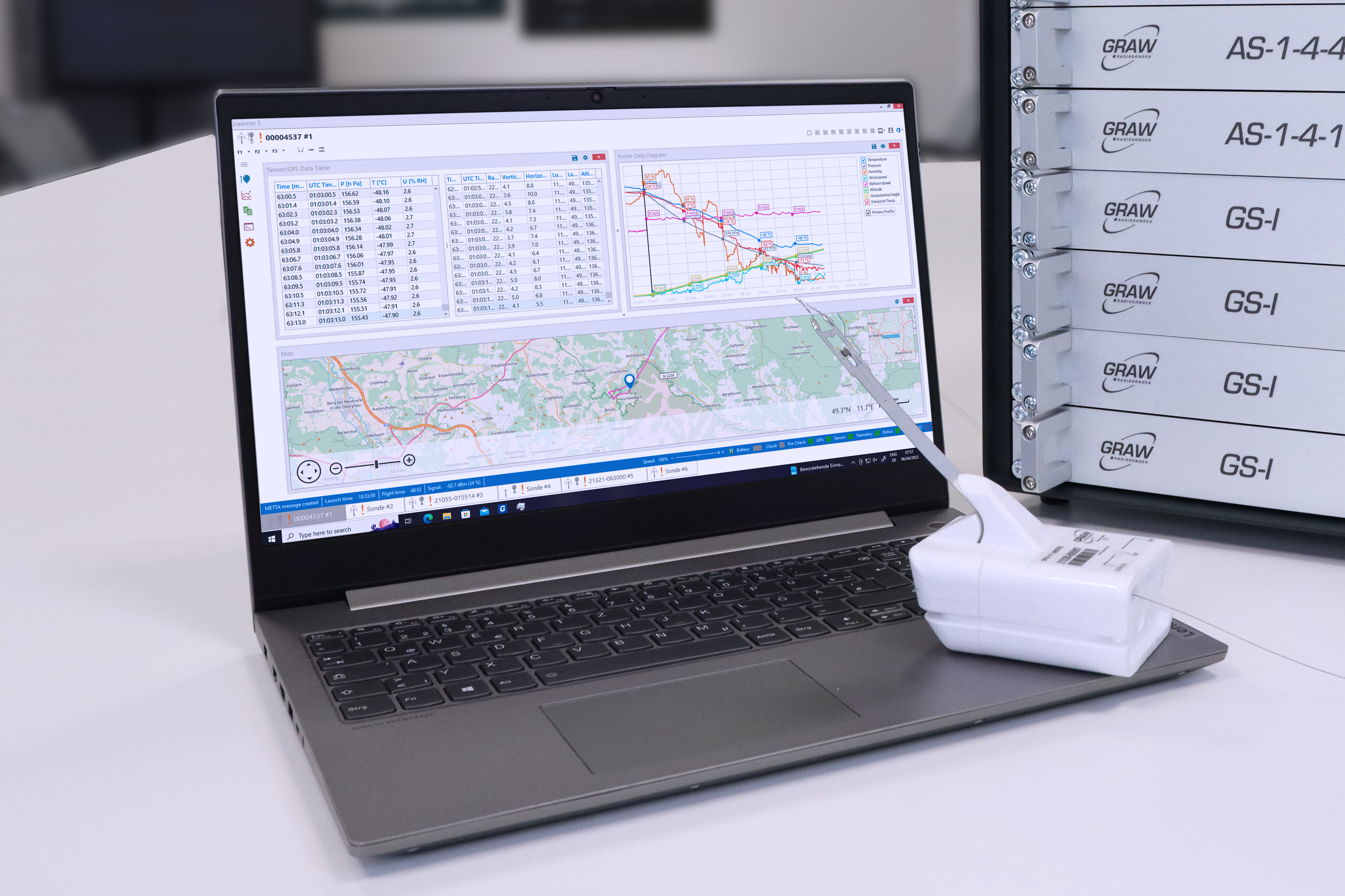 The image shows s scene in a office with a notebook, radiosonde and GS-I groundstation of Graw Radiosondes